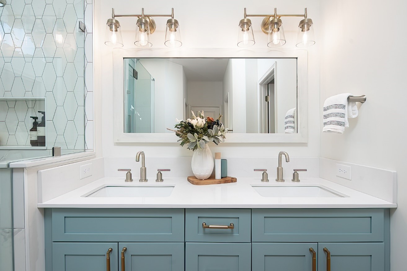 Double vanity with sea-green cabinetry, quartz counter and brushed nickel fixtures