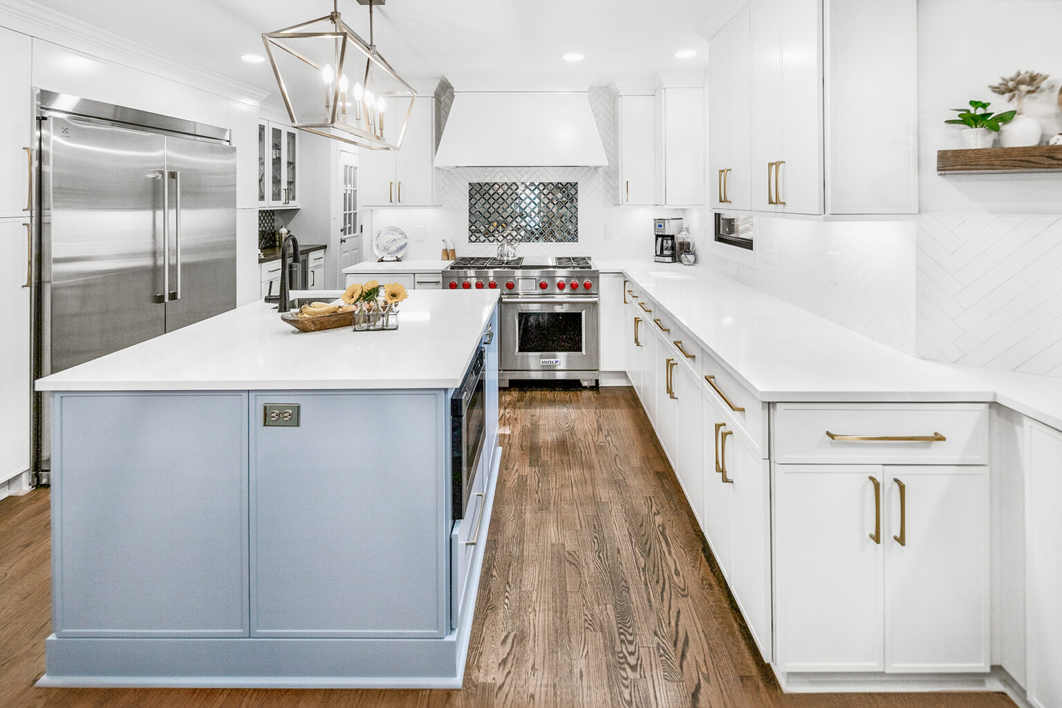 Completed kitchen with a pale blue island, white cabinetry and a professional range